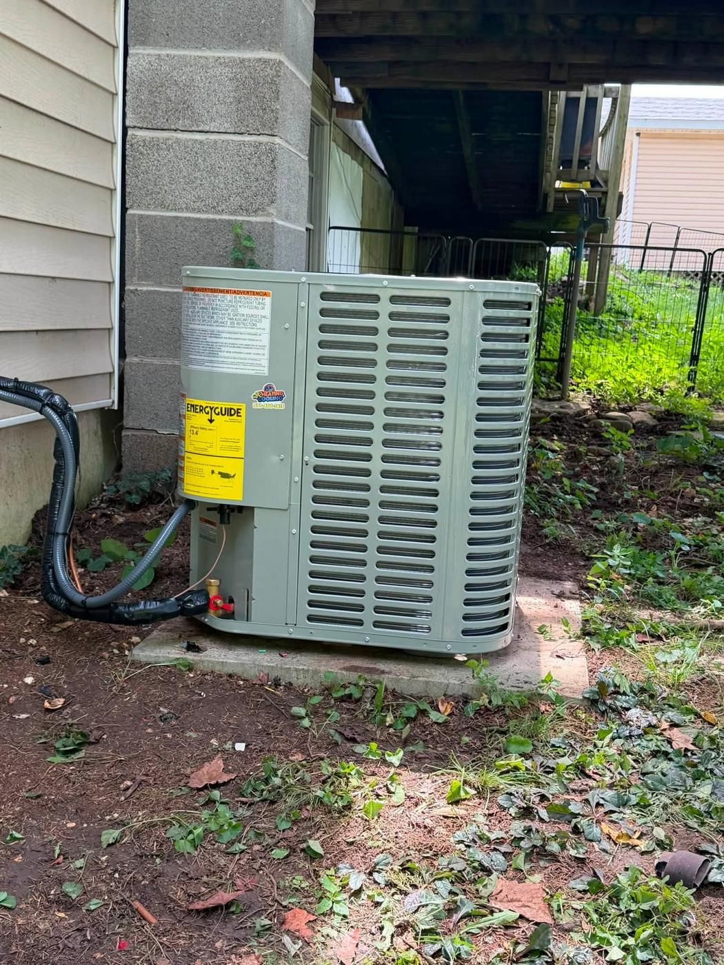 Oxbox condenser set on a pad beside a block pier under a deck